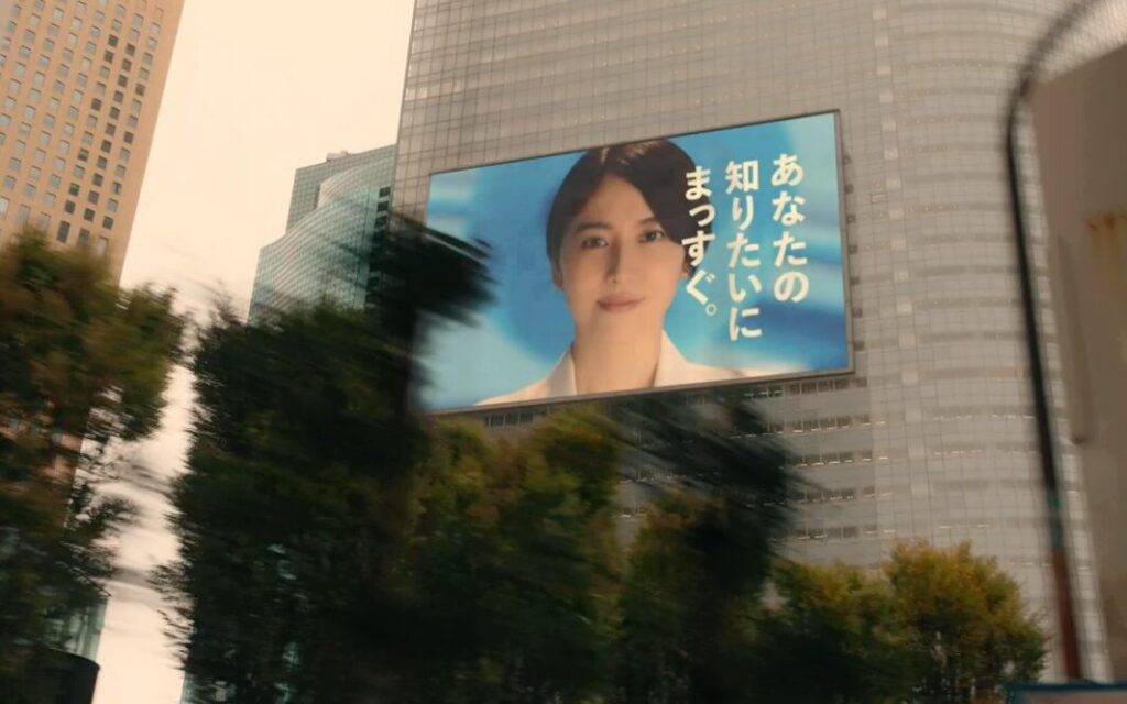 ドラマ「エルピス―希望、あるいは災い―」第８話、びるにあるニュース８の巨大広告、浅川恵那（長澤まさみ）の顔の横に「あなたの知りたにまっすぐ。」というキャッチコピー