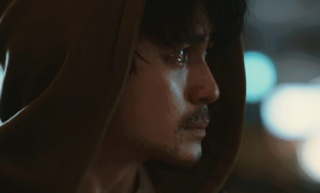 ドラマ「エルピス―希望、あるいは災い―」第８話、会社を解雇された後、会社前にある『ニュース８』浅川恵那（長澤まさみ）の映像を見つめる岸本拓朗（眞栄田郷敦）