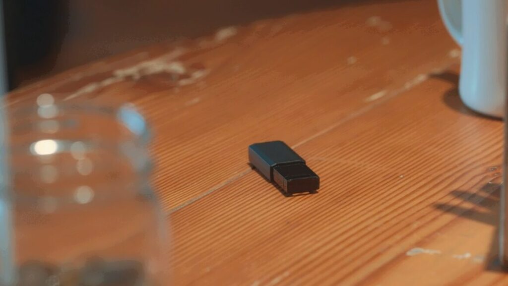 ドラマ「エルピス―希望、あるいは災い―」第７話、カフェで八飛署の刑事・平川勉（安井順平）がテーブルの上に置いていったUSBメモリー