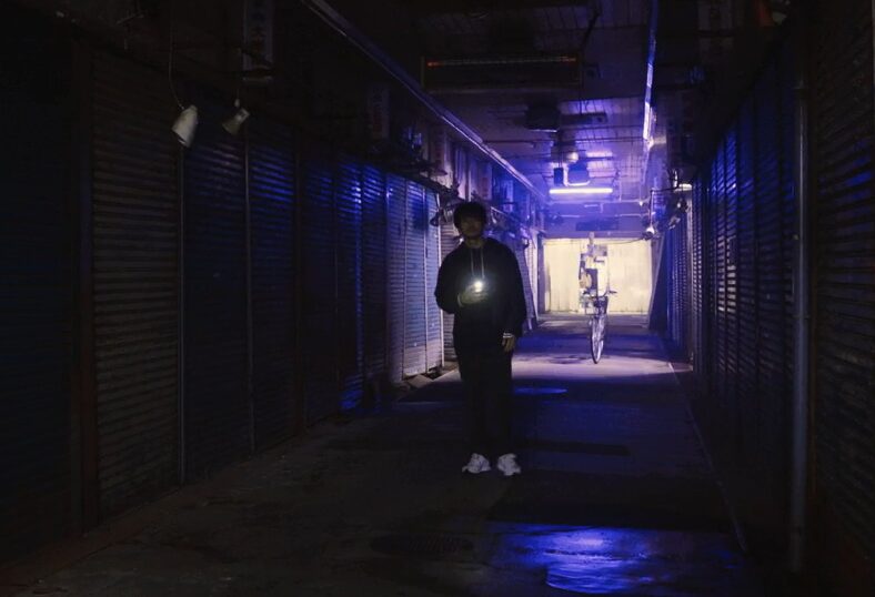 ドラマ「エルピス―希望、あるいは災い―」第６話、八飛市のシャーった街商店街の写真を撮る岸本拓朗（眞栄田郷敦）