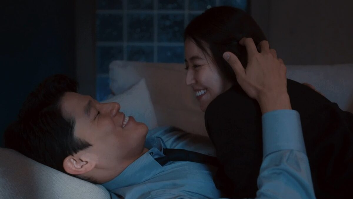 ドラマ「エルピス―希望、あるいは災い―」第６話、自宅のソファで微笑み合う浅川恵那（長澤まさみ）と斎藤正一（鈴木亮平）