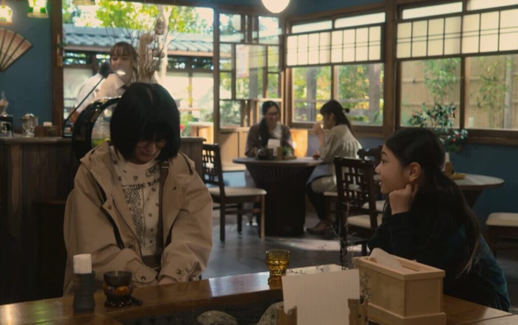 ドラマ「妻、小学生になる。」第１話、『喫茶たいむ』で新島麻衣（蒔田彩珠）に話しかけている白石万理華（毎田暖乃）　
