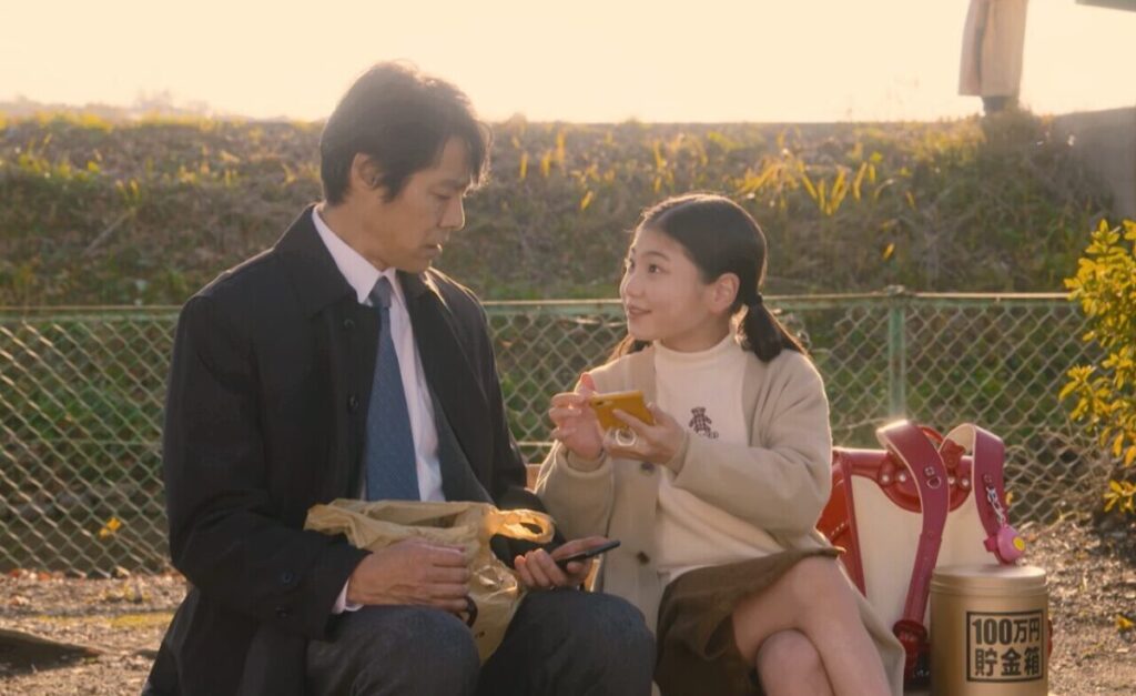 ドラマ「妻、小学生になる。」第１話、公園のベンチで新島圭介(堤真一)とLINEの交換をする白石万理華（毎田暖乃）