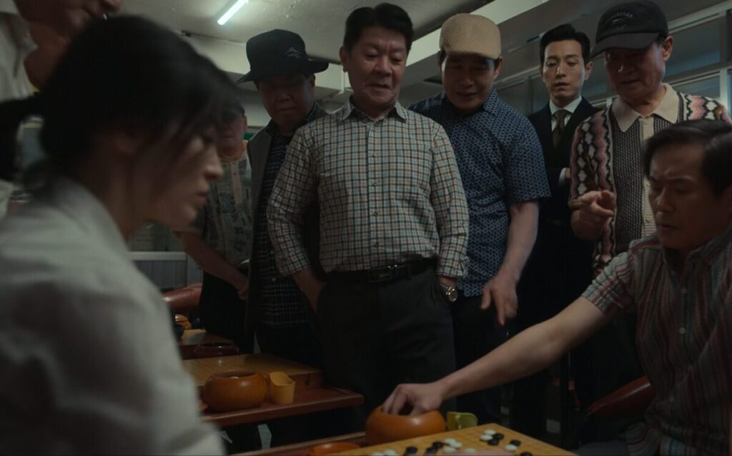 ドラマ「ザ・グローリー ~輝かしき復讐~」第3話、棋院で囲碁をしているムン・ドンウン(ソン・ヘギョ)をやじ馬に交じって一緒に見ているハ・ドヨン(チョン・ソンイル)