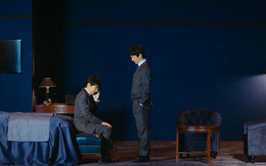 ドラマ「VIVANT」第1話、ホテルの部屋からサムに電話をかける乃木憂助(堺雅人)、その向かいにはF(堺雅人)が立っている