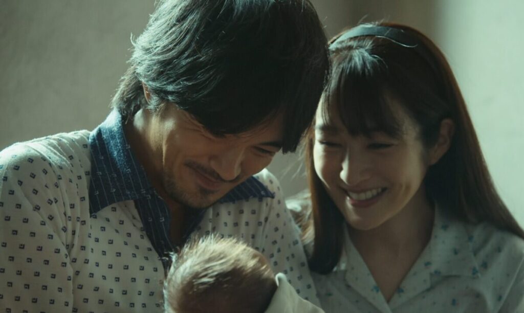 ドラマ「VIVANT・第1シーズン」第9話、生まれたばかりの乃木憂助（堺雅人）を見て笑みを浮かべている若き日のベキ（林遣都）と妻・明美（高梨臨）